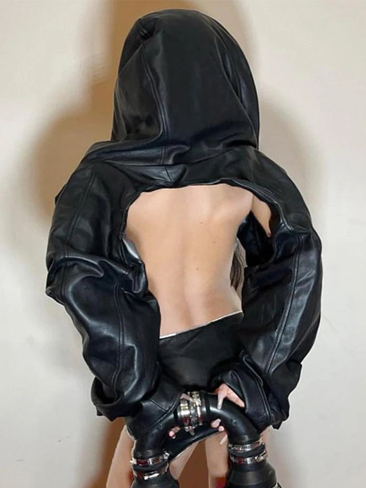 Person wearing a black leather outfit with a hood on a plain background